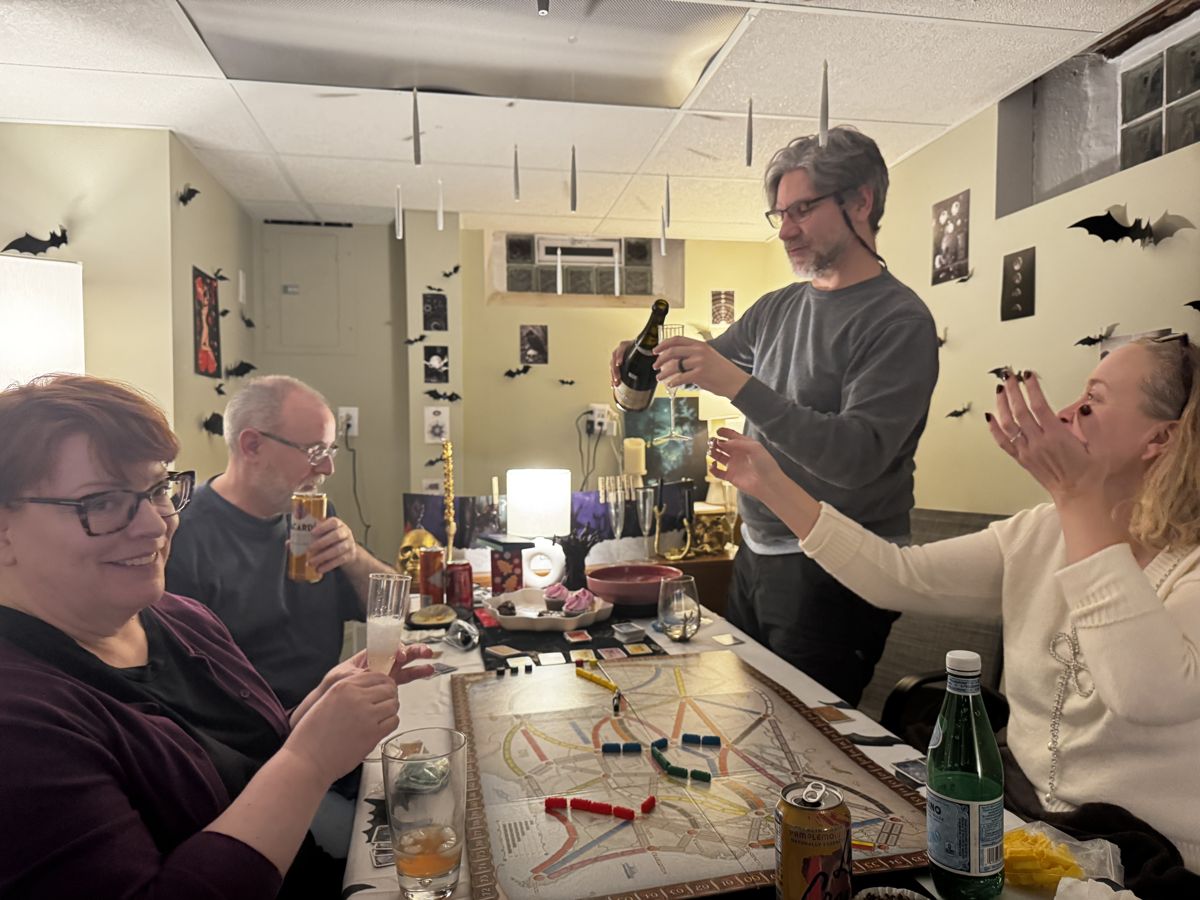 Friends toasting with champagne over a board game