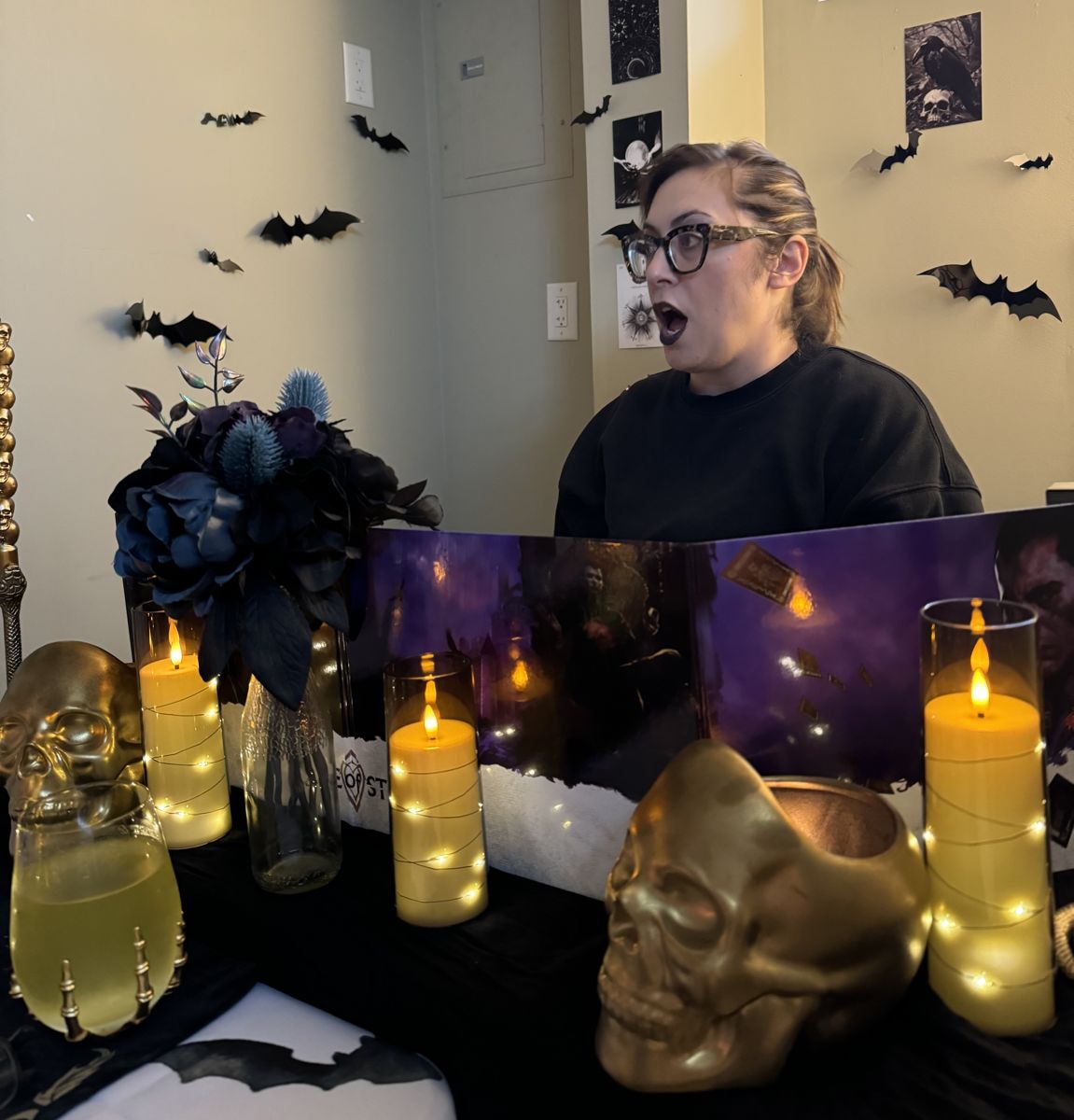 A game master mid-story at a candlelit table with gold skulls